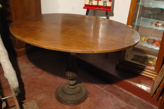 Tavolo ovale, con piano in noce e base in ghisa